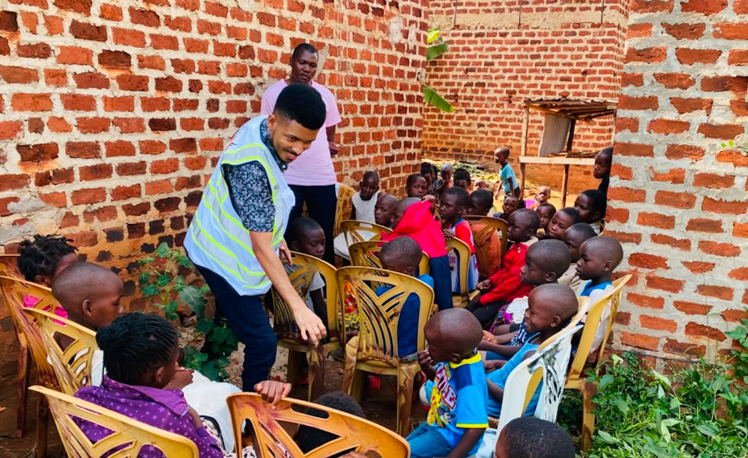 A volunteer speaking with seated children